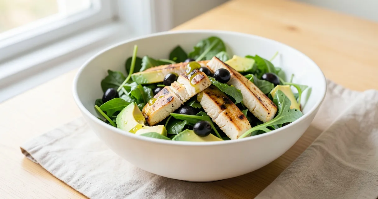 Ensalada mediterránea con hojas verdes, aguacate, pollo a la plancha y aceitunas